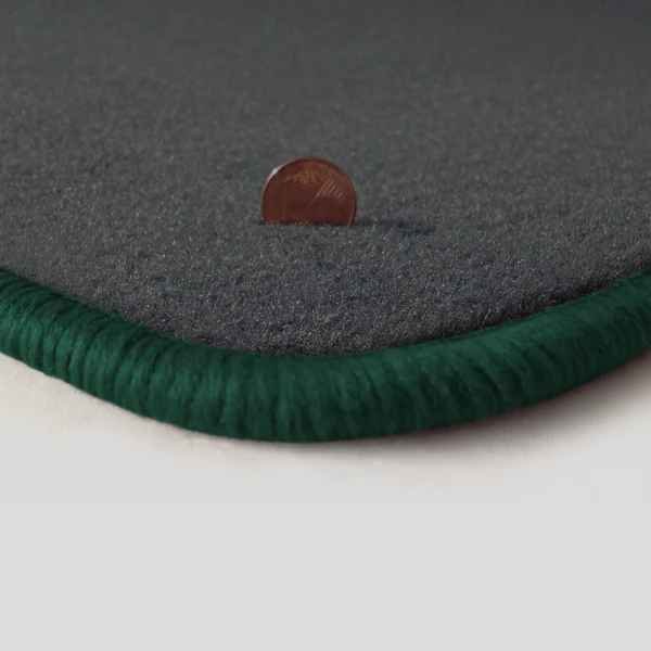 Eine Ecke als Beispiel einer Fussmatte Velours dunkelgrau mit Rand in dunkelgruen.