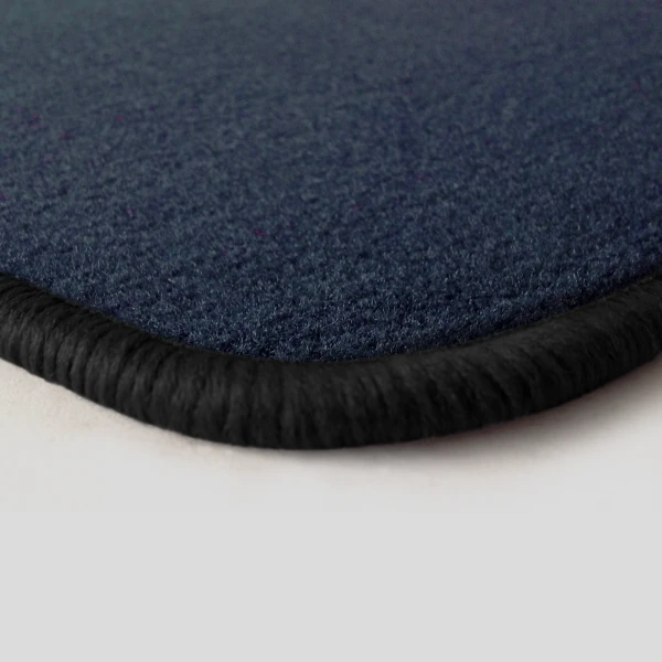Eine Ecke als Beispiel einer Fussmatte Velours dunkelblau mit Rand in schwarz.