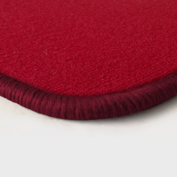 Eine Ecke als Beispiel einer Fussmatte Velours rot mit Rand in bordeaux.