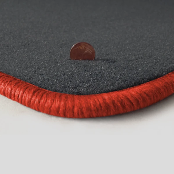 Eine Ecke als Beispiel einer Fussmatte Velours dunkelgrau mit Rand in orange.