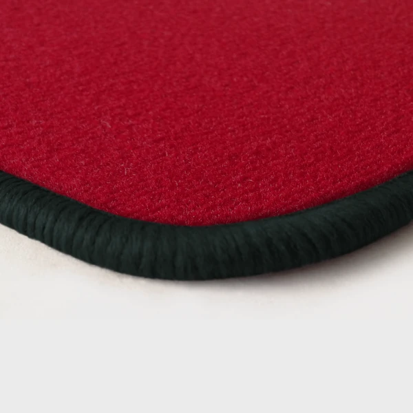 Eine Ecke als Beispiel einer Fussmatte Velours rot mit Rand in anthrazit.