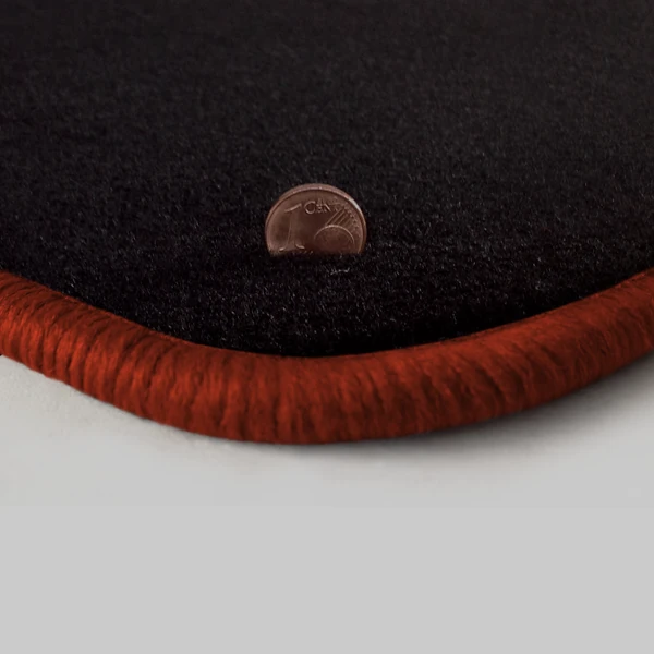 Eine Ecke als Beispiel einer Fussmatte Velours schwarz mit Rand in kupfer.