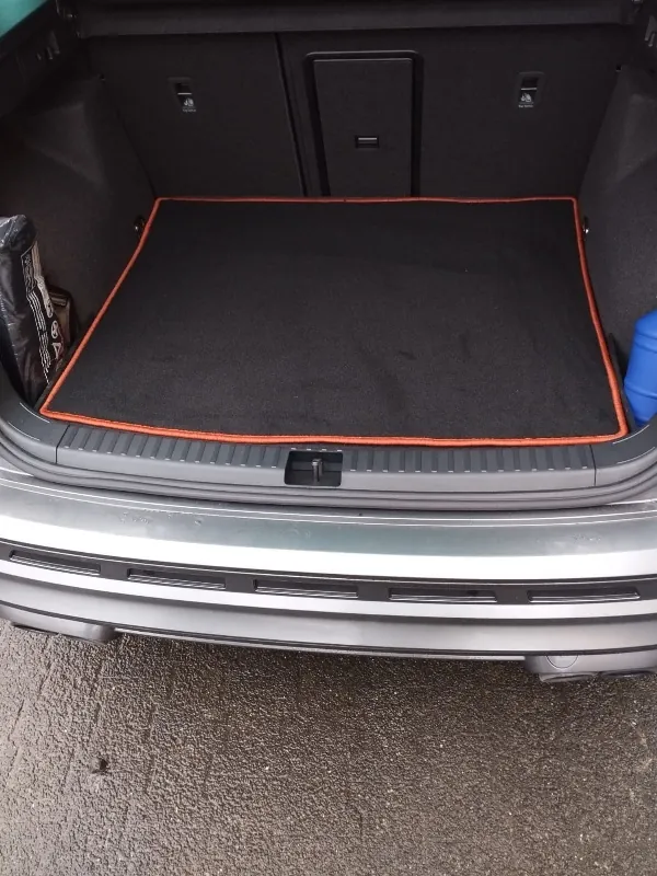 Blick in den Kofferaum eines Cupra Ateca, verkleidet mit einer schwarzen Kofferraummmatte mit rotem Rand.