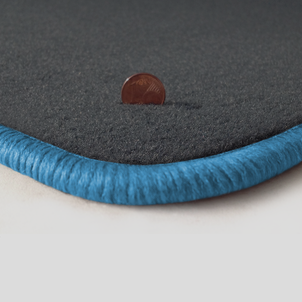 Eine Ecke als Beispiel einer Fussmatte Velours dunkelgrau mit Rand in hellblau.