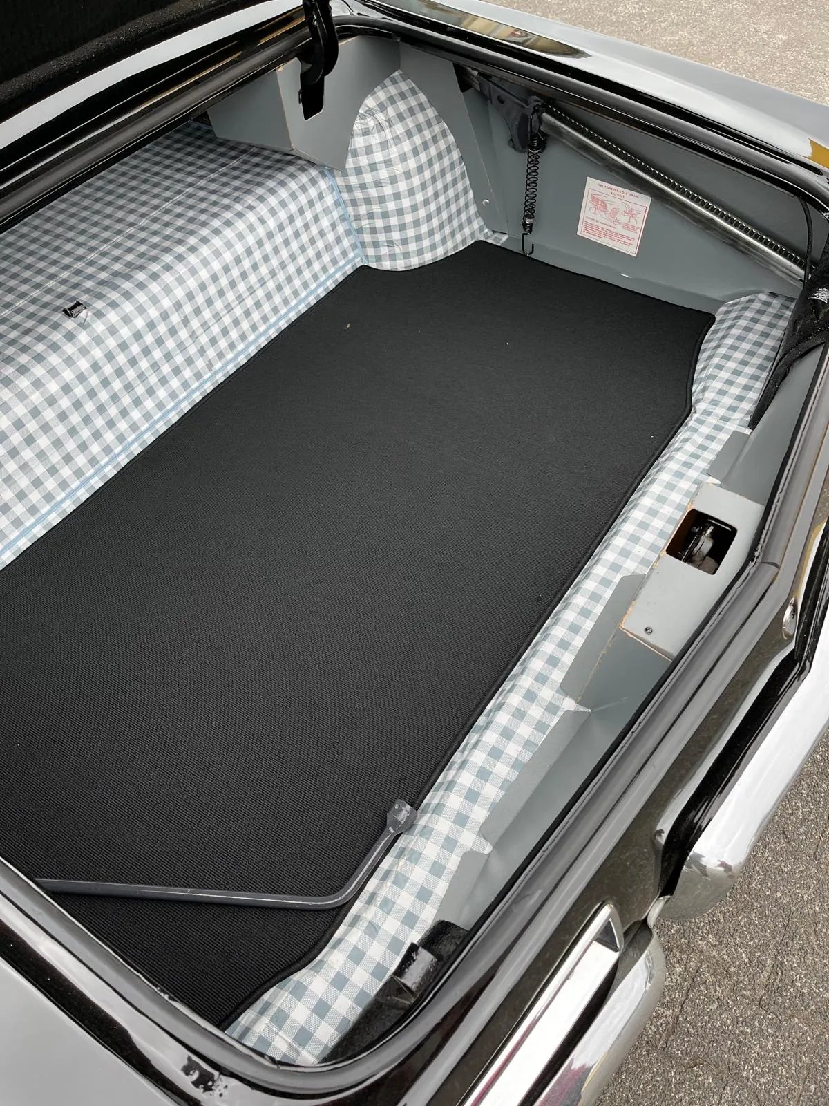 Blick in den Kofferaum eines Buick Riviera 1964, verkleidet mit einer schwarzen Kofferraummmatte.