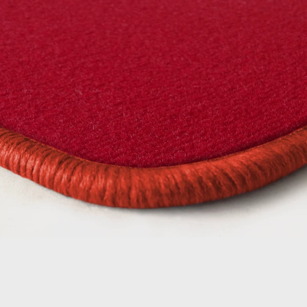 Eine Ecke als Beispiel einer Fussmatte Velours rot mit Rand in orange.