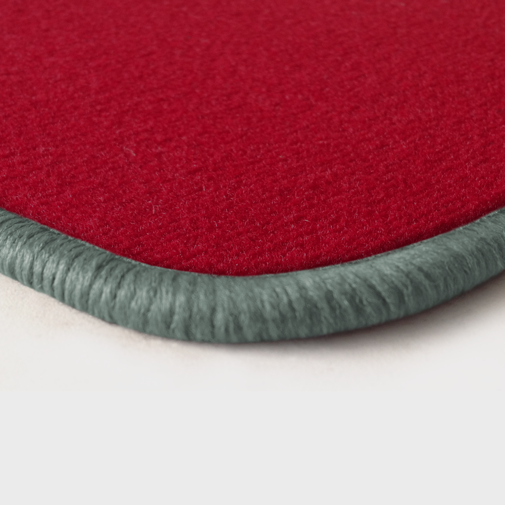 Eine Ecke als Beispiel einer Fussmatte Velours rot mit Rand in silbergrau.