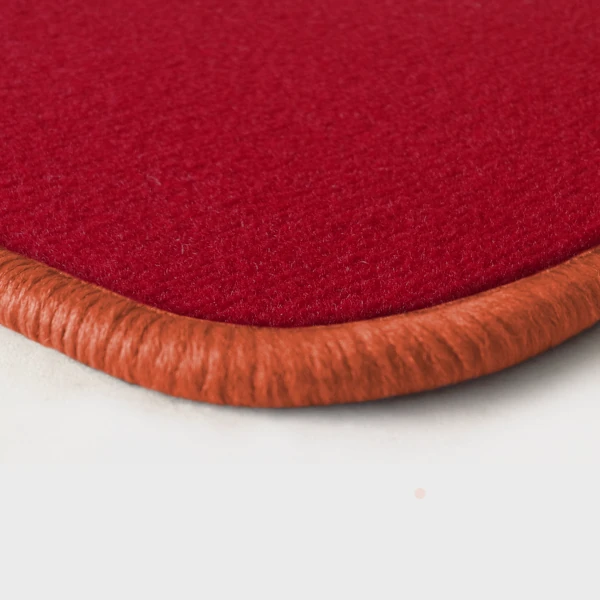 Eine Ecke als Beispiel einer Fussmatte Velours rot mit Rand in lachs.
