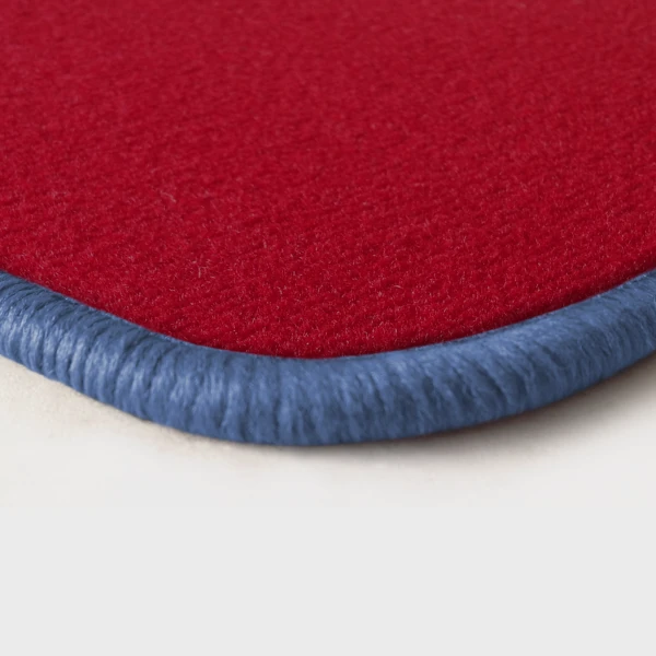 Eine Ecke als Beispiel einer Fussmatte Velours rot mit Rand in flieder.
