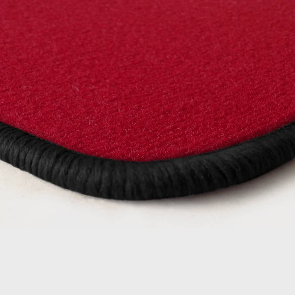Eine Ecke als Beispiel einer Fussmatte Velours rot mit Rand in schwarz.