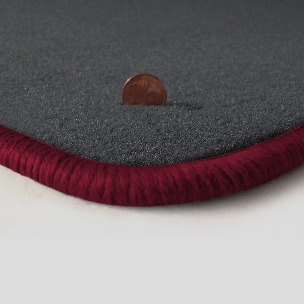 Eine Ecke als Beispiel einer Fussmatte Velours dunkelgrau mit Rand in bordeaux.