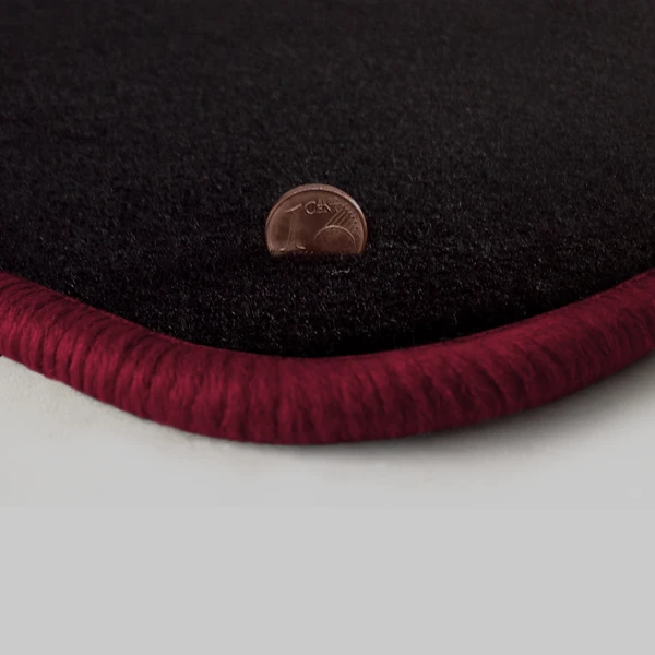 Eine Ecke als Beispiel einer Fussmatte Velours schwarz mit Rand in bordeaux.