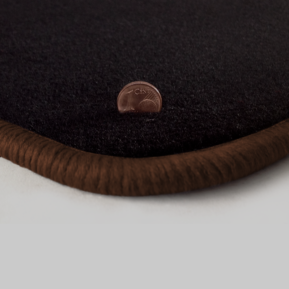 Eine Ecke als Beispiel einer Fussmatte Velours schwarz mit Rand in braun.