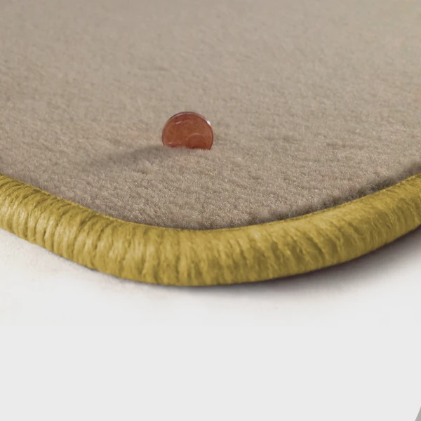 Eine Ecke als Beispiel einer Fussmatte Velours beige mit Rand in safran.