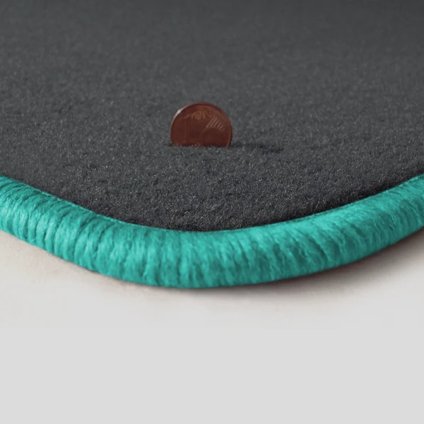 Eine Ecke als Beispiel einer Fussmatte Velours dunkelgrau mit Rand in mint.