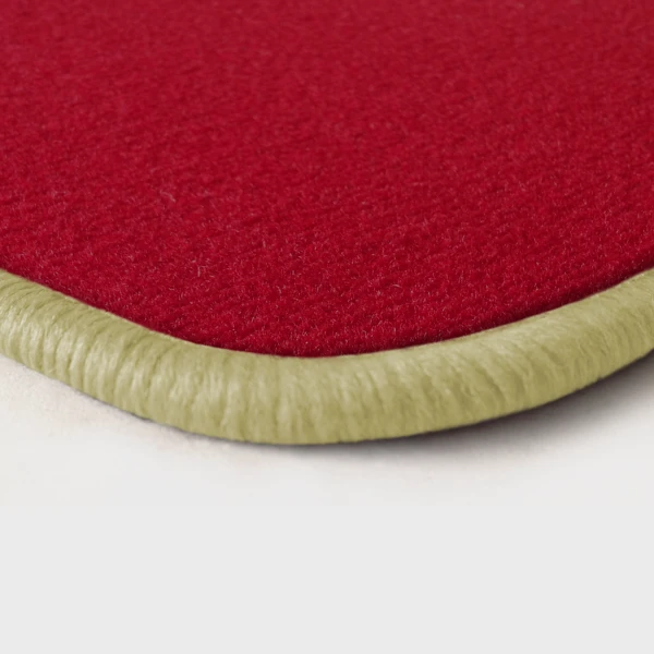Eine Ecke als Beispiel einer Fussmatte Velours rot mit Rand in hellbeige.