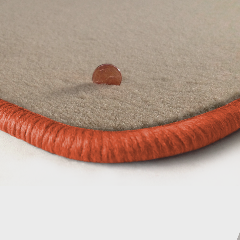 Eine Ecke als Beispiel einer Fussmatte Velours beige mit Rand in lachs.