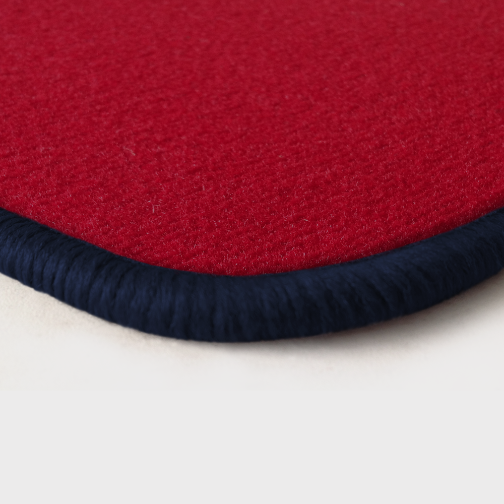 Farbmuster Ecke rot Q103-detail 312-dunkelblau Eine Ecke als Beispiel einer Fussmatte Velours rot mit Rand in dunkelblau.