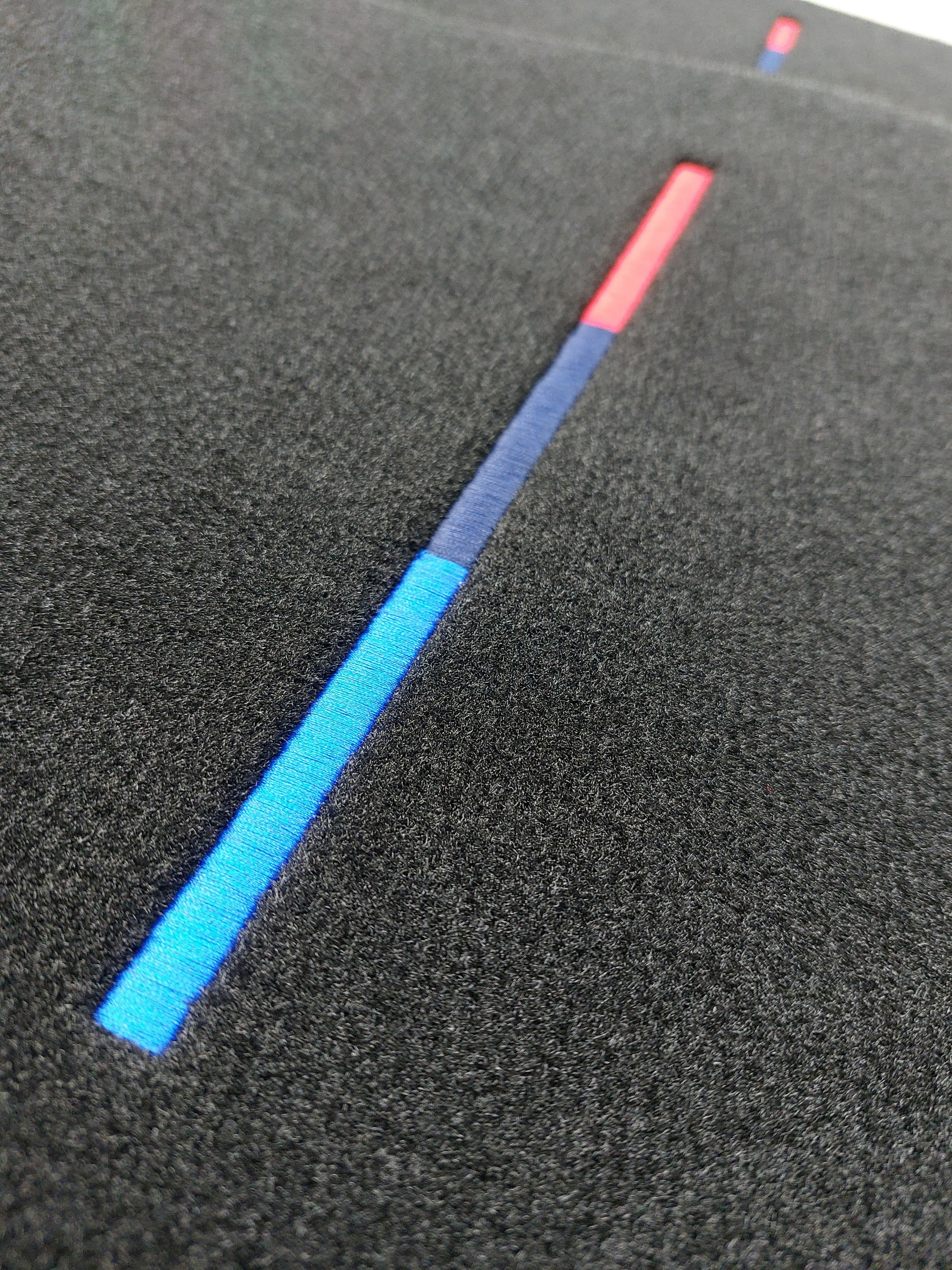 bestickte Logo M-Farben BMW Eine Detail Aufnahme des Stick Logos in M-Farben.