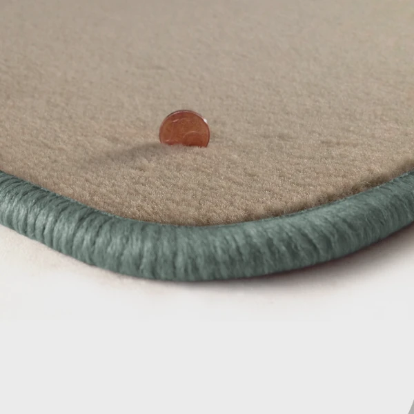 Eine Ecke als Beispiel einer Fussmatte Velours beige mit Rand in silbergrau.