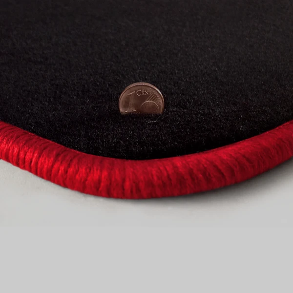 Eine Ecke als Beispiel einer Fussmatte Velours schwarz mit Rand in rot.