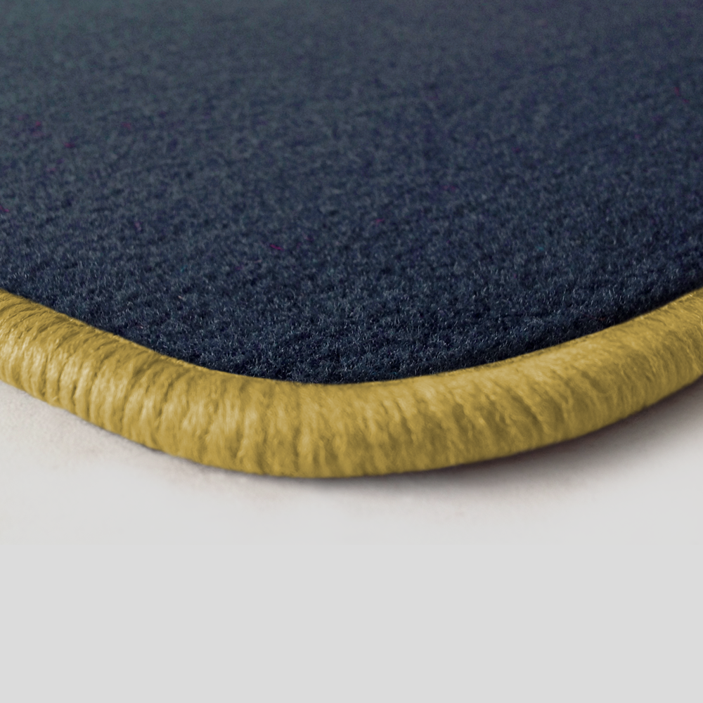 Eine Ecke als Beispiel einer Fussmatte Velours dunkelblau mit Rand in safran.