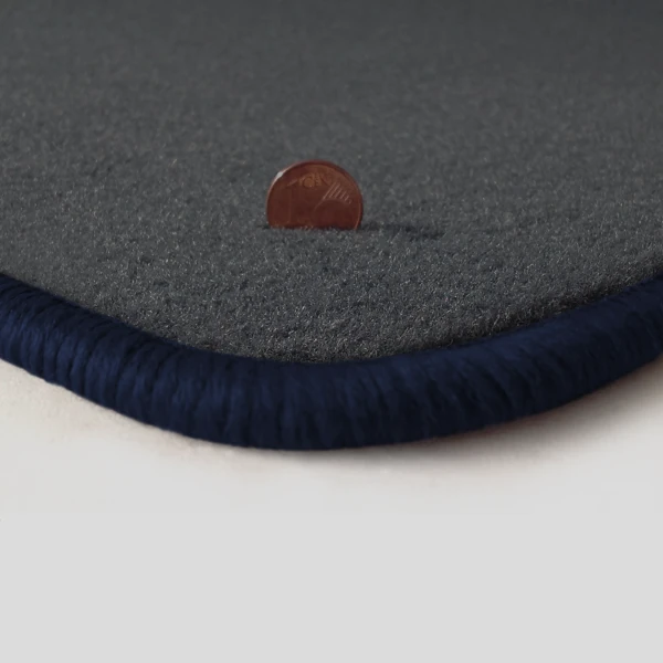 Eine Ecke als Beispiel einer Fussmatte Velours dunkelgrau mit Rand in dunkelblau.