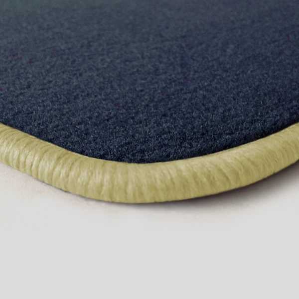 Eine Ecke als Beispiel einer Fussmatte Velours dunkelblau mit Rand in hellbeige.